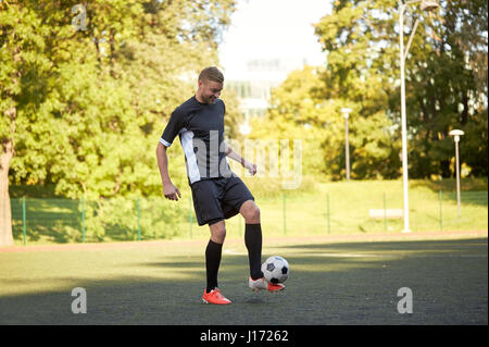 Fußball-Spieler spielen mit Ball auf Feld Stockfoto