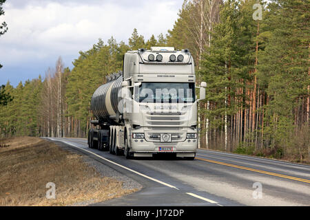 SALO, Finnland - 7. April 2017: Cremige weiße super Scania R580 Tankwagen für Transport von Trans Matti Salo bewegt sich entlang der Autobahn flankiert von Wald Stockfoto