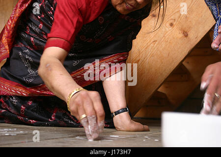 Hinduistische Frau Zeichnung kolam Muster auf dem Boden Stockfoto