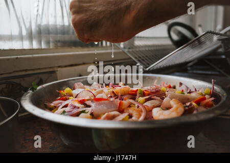 Mann, die Peruanische Meeresfrüchte Ceviche in der Küche vorbereiten Stockfoto