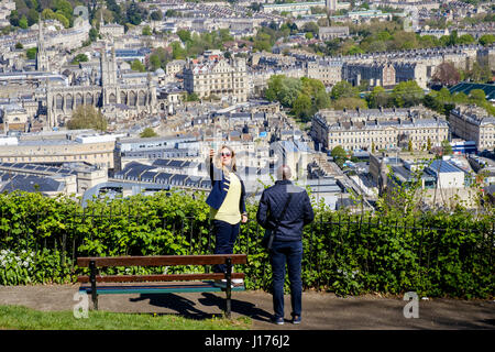 Bath, Großbritannien. 18. April 2017. Mit der Stadt Bad hinter ihr ist eine Frau, die unter Ausnutzung der warmen Frühlingssonne und einem hohen Aussichtspunkt abgebildet, als sie ein Selbstporträt in Alexandra Park nimmt. Bildnachweis: Lynchpics/Alamy Live-Nachrichten Stockfoto