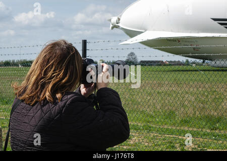 Cardington, Bedfordshire, UK. 18. April 2017. Die Hybrid Air Fahrzeuge Airlander 10 liegt, die neue Mobile Mooring Mast (MMM), Fotografin schießt durch den Maschendrahtzaun auf dem Flugplatz. Ein Auxiliary Landing System (ALS) wurde hinzugefügt, wodurch das Flugzeug sicher zu landen, auf eine größere Reichweite der Landung Winkel. Bildnachweis: Mick Flynn/Alamy Live-Nachrichten Stockfoto