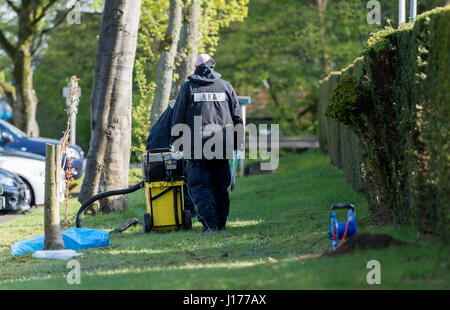 Dortmund, Deutschland, 18. April 2017. Zwei Polizisten des Office of Criminal Investigation aufräumen Spuren aus einem Rasen auf dem Gelände des Angriffs in Dortmund, Deutschland, 18. April 2017. Hoffen Sie eine Woche nach dem explosiven Angriff auf den Mannschaftsbus der deutschen Fußball-Bundesliga-Fußball-Club Borussia Dortmund, Ermittler, neue Erkenntnisse aus der Rekonstruktion des Angriffs vor Ort zu finden. Am 11. April drei Sprengsätze gezündet neben den Mannschaftsbus des BVB in Dortmund. Der Spieler Bartra und ein Verantwortlicher der Polizei wurden bei dem Angriff verletzt. Die verantwortliche Person ist unbekannt. Dpa/Alamy Live-Nachrichten Stockfoto