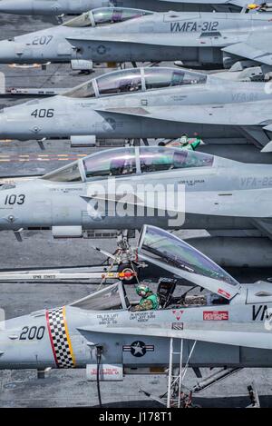 USS Theodore Roosevelt, Vereinigte Staaten von Amerika. 17. April 2017. Ein US-Marine inspiziert die Flugsteuerung von einer F/A-18 Hornet, 17. April 2017 im Pazifischen Ozean, die Schachbretter der Marine Strike Fighter Angriff Geschwader 312, auf dem Flugdeck an Bord der Flugzeugträger der Nimitz-Klasse USS Theodore Roosevelt zugewiesen. Der Flugzeugträger führt im Gange Training vor der Küste von Süd-Kalifornien. Bildnachweis: Planetpix/Alamy Live-Nachrichten Stockfoto