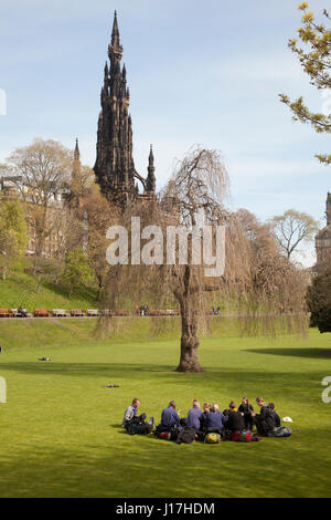 Princess Gardens, Edinburgh, Schottland, Großbritannien. 18. April 2017. Sonniges Wetter, leichtem Wind. Gruppe von Rucksacktouristen, die sitzen auf ihren Taschen auf dem Rasen im Park genießen sonniges Wetter in Edinburgh, Schottland. Bildnachweis: Gabriela Antosova/Alamy Live-Nachrichten Stockfoto