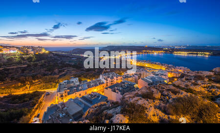 Il-Mellieha, Malta-schöne Panorama Skyline Blick auf Mellieha Bay nach Sonnenuntergang mit blauen Himmel und Wolken Stockfoto