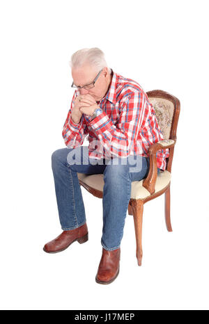 Ein Bild eines weißen Haaren Senior Mann in ein kariertes Hemd und Brille in einem Sessel sitzen und denken, für weißen Hintergrund isoliert. Stockfoto