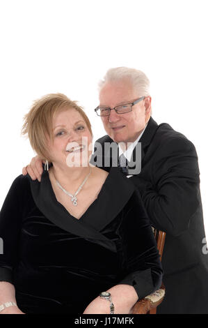 Ein schönes Senioren paar stehen und umarmen einander in Anzügen für weißen Hintergrund isoliert. Stockfoto