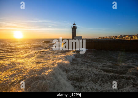 Sonnenuntergang in der Nähe des Leuchtturms auf der atlantischen Küste von Porto, Portugal. Stockfoto