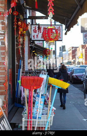 Straßenszene in Toronto Kanada. Geschäft in Chinatown bunte Haushaltsgegenstände zu verkaufen.  die Menschen gehen durch helle farbige Besen zum Verkauf auf dem Bürgersteig. Stockfoto