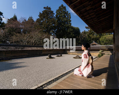 Junge Japanerin Kimono kniet neben den Steingarten an Ryōan-Ji, Kyoto. Eines der schönsten Beispiele für einen Verleih-Niwa Steingarten. Zen meditatio Stockfoto