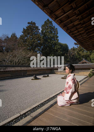 Junge Japanerin Kimono kniet neben den Steingarten an Ryōan-Ji, Kyoto. Eines der schönsten Beispiele für einen Verleih-Niwa Steingarten. Zen meditatio Stockfoto