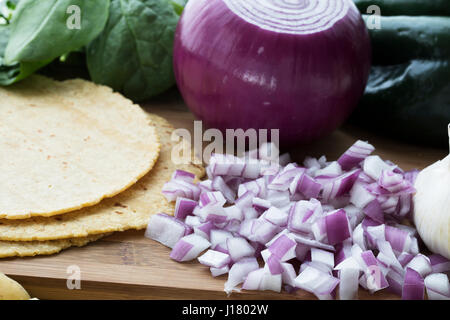 Gehackte rote Zwiebeln mit Mais-Tortillas und anderen Zutaten. Stockfoto