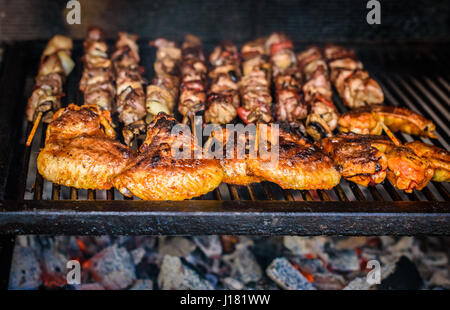 Fleischspieße und Huhn auf natürliche Holzkohle Grill Grillen. Ein großes Steak auf natürliche Brennholz BBQ im außen Kamin vorbereiten. Stockfoto