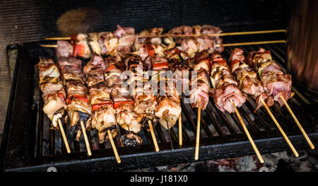 Fleischspieße auf natürliche Holzkohle Grill Grillen. Ein großes Steak auf natürliche Brennholz BBQ im außen Kamin vorbereiten. Stockfoto