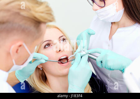 Zwei Zahnärzte behandeln ihre Zähne Besucher in Zahnarztpraxis Stockfoto
