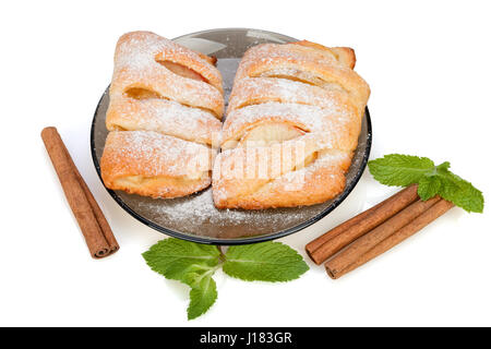 Brötchen mit Apfel, Zimt und Minze bestreut mit Puderzucker auf einem Teller.  Isoliert auf weißem Hintergrund. Stockfoto