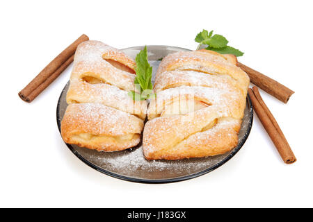 Brötchen mit Apfel, Zimt und Minze bestreut mit Puderzucker auf einem Teller.  Isoliert auf weißem Hintergrund. Stockfoto