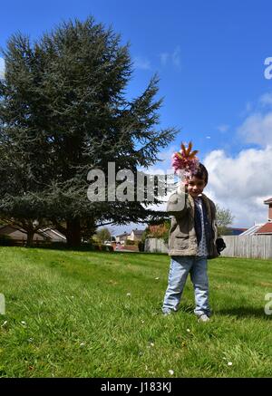 Kleiner Junge mit Kirschblüten Blumen an einem hellen Tag Stockfoto