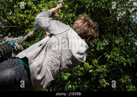 Junge spielt auf Seil schwingen, UK Stockfoto