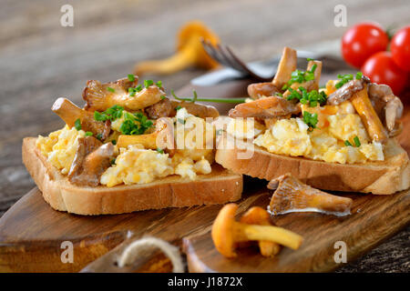 Frühstück mit Rührei und frischen gebratenen Pfifferlingen auf toast Stockfoto