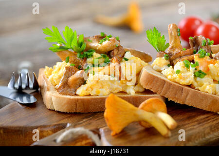 Frühstück mit Rührei und frischen gebratenen Pfifferlingen auf toast Stockfoto