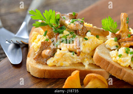 Frühstück mit Rührei und frischen gebratenen Pfifferlingen auf toast Stockfoto
