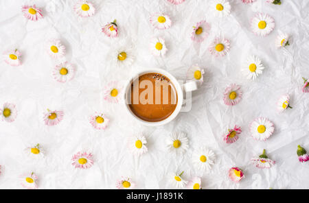 Tasse Kaffee und Daisy Blumen auf weißem Stoff Stockfoto