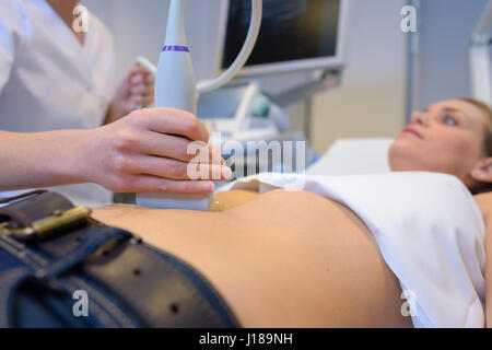 Frau, die Untersuchung des Bauches Stockfoto