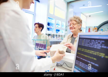 Apotheker Medikamente an Kunden übergeben Stockfoto