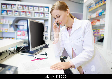 Apotheker im Gespräch mit Kunden per Telefon Stockfoto