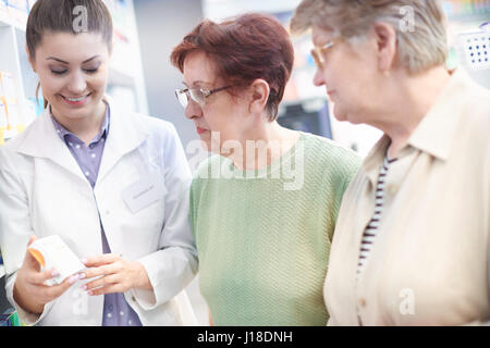 Apotheker mit Reife Kunden in Drogerie Stockfoto