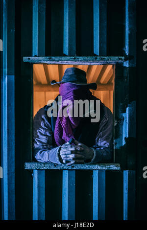 Maskierter Mann in das Fenster von einem Nebengebäude. Stockfoto