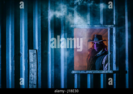 Maskierter Mann in das Fenster von einem Nebengebäude. Stockfoto