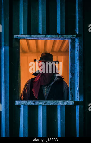 Maskierter Mann in das Fenster von einem Nebengebäude. Stockfoto