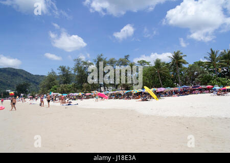 Touristen unter Sonnenschirmen am Patong Beach, Phuket, Thahiland Stockfoto