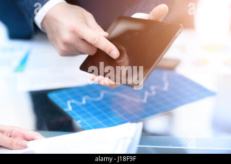 Business Mann im Büro arbeiten mit Laptop, Tablet und Darstellung der Daten Dokumente auf seinem Schreibtisch. Stockfoto