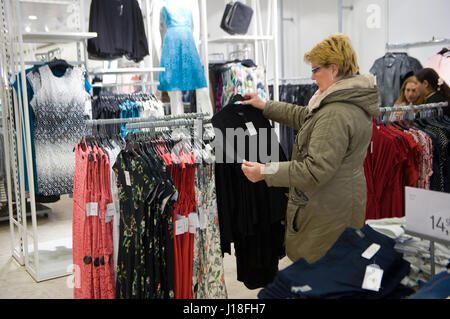 ENSCHEDE, Niederlande - 13. April 2017: Eine Frau ist im Bekleidungsgeschäft C & A einkaufen, nachdem es wieder geöffnet worden. Stockfoto