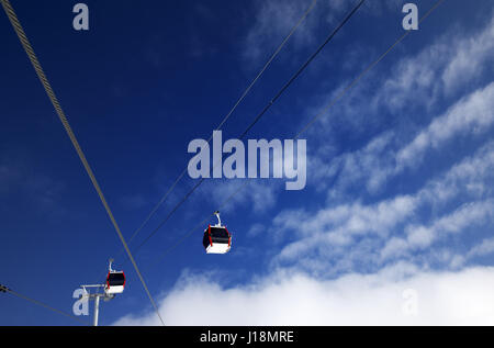 Gondel Liftanlagen im Skigebiet und blauer Himmel mit Wolken im schönen Tag. Weitwinkel, Ansicht von unten. Stockfoto