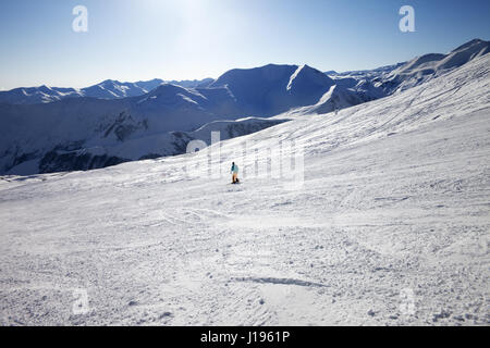 Skifahrer am Hang in Sonnetag. Kaukasus, Georgien, Region Gudauri. Weitwinkelaufnahme. Stockfoto