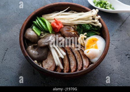 Schüssel Ramen-Nudeln mit Ei, Enoki, Shiitake-Pilze, Ente und Zwiebeln Stockfoto