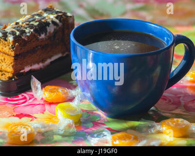 Die Tasse Kaffee, Kuchen und Süßigkeiten auf Tisch Stockfoto