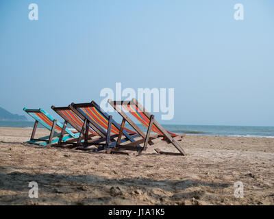 Vier Liegestühle am Strand Stockfoto