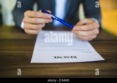 Geschäftsmann oder Arbeitsuchende überprüfen Sie seinen Lebenslauf auf seinem Schreibtisch vor dem Senden an einen neuen Job mit Kugelschreiber, Notizbuch, Gläser und digital-Tablette zu finden. Stockfoto