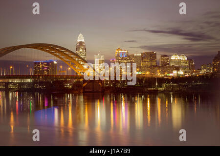 Foto von Cincinnati, Ohio USA. Bild kurz nach Sonnenuntergang. Der Ohio River steht im Vordergrund und die Dan C Beard Brücke ist auf der linken Seite. Stockfoto