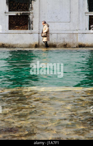 Venedig, Italien - 2. Februar 2015: Menschen bewältigen mit der überfluteten Straße in Cannaregio, Venedig, Veneto, Italien Stockfoto