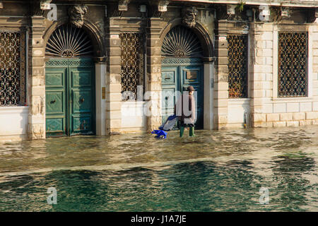 Venedig, Italien - 2. Februar 2015: Menschen bewältigen mit der überfluteten Straße in Cannaregio, Venedig, Veneto, Italien Stockfoto