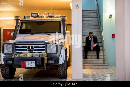 Bagdad, Irak. 19. April 2017. Der deutsche Außenminister Sigmar Gabriel spricht am Telefon während der Sitzung in eine Treppe neben ein gepanzertes Fahrzeug bei der deutschen Botschaft in Bagdad, Irak, 19. April 2017. Foto: Kay Nietfeld/Dpa/Alamy Live News Stockfoto