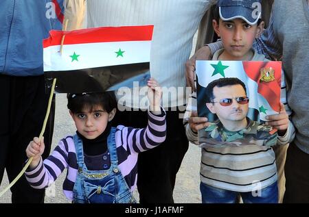 (170419)--Damaskus, 19. April 2017 (Xinhua)--Syrer halten eine syrische Flagge und ein Portrait von Präsident Bashar al-Assad in der Stadt Zabadani, westlichen Landschaft von Damaskus, Hauptstadt von Syrien, nach der Evakuierung der letzten Rebellengruppe aus ihrer Stadt am 19. April 2017. Insgesamt sechs Städte westlich von der Hauptstadt Damaskus werden frei von Rebellen, nach einer groß angelegten Evakuierung-Deal, der am Mittwoch geschlossen wurde sagte eine militärische Quelle Xinhua. Die Städte von Madaya, Zabadani und Buqain, Serghaya, Bludan und Eastern Mountain, in der westlichen Gegend von Damaskus, in der Nähe sind jetzt frei Stockfoto