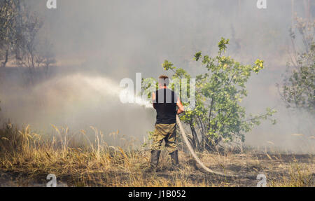 Ein Feuerwehrmann löscht Wald Wildfire, Donbass, Ukraine. Stockfoto
